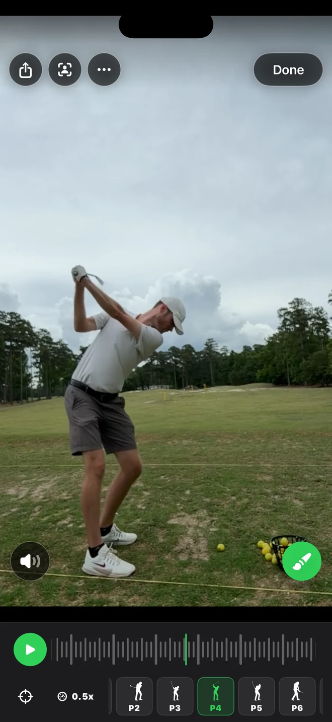 Swing review screen with the Coach Review person-in-frame icon in the top toolbar and playback controls below the video